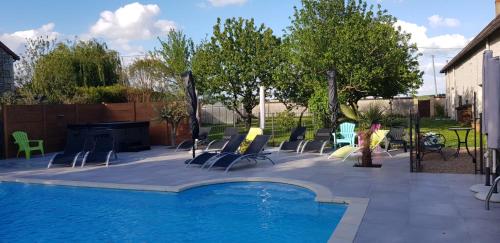 a woman is standing next to a swimming pool at Gîte et chambres d'hôtes Le Chêne Billault in Pouant