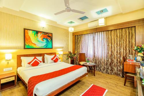 a hotel room with a bed and a desk at Octave Kanthi Comforts in Bangalore