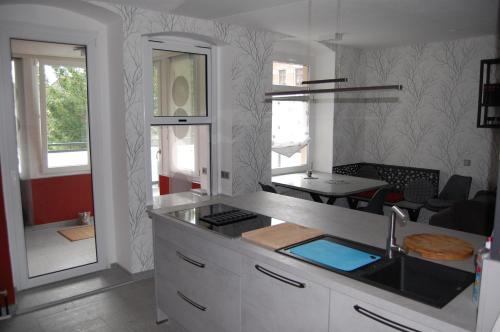 ライヒェンバッハ・イム・フォークトラントにあるHochwertige Ferienwohnung/zentrumsnahe Lage!のシンクとカウンタートップのあるキッチン