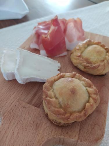 a wooden cutting board with two pies and other foods at Il Sentiero B&Bìo in SantʼAntìoco