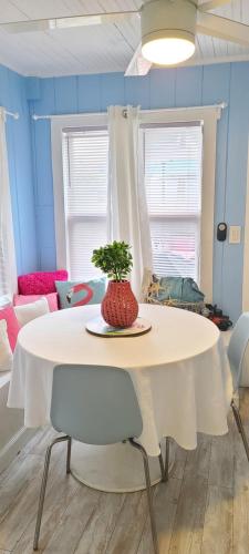 a white table with a vase on it in a room at Lake Worth Beach Paradise Cove Cottage 2-1Bedroom in Lake Worth