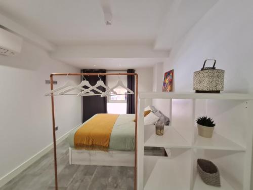 a bedroom with a bed and a white wall at LoftinMalaga in Málaga