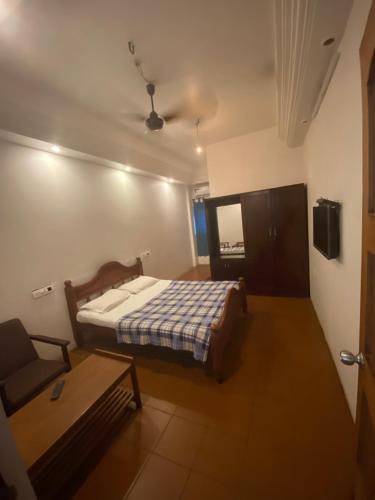 a bedroom with a bed and a table in it at Saj Rest' inn in Kannur