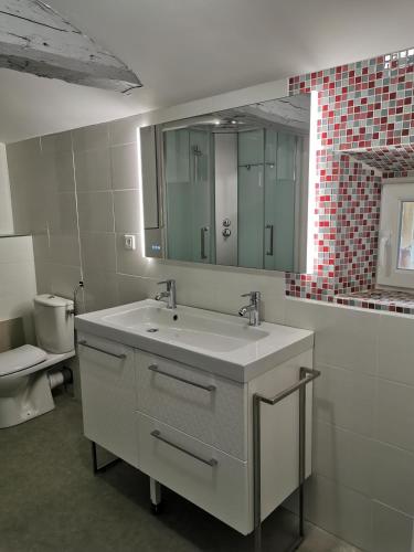 une salle de bain avec un lavabo et des toilettes dans l'établissement La Longère de Mina, à La Petite-Boissière