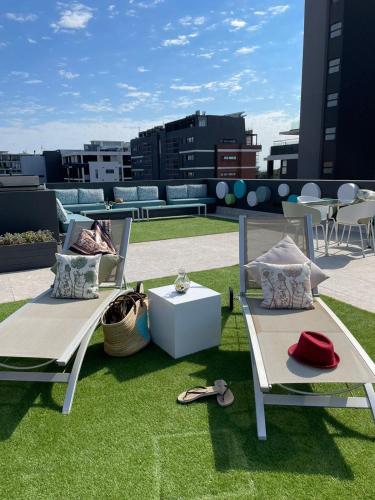 a patio with two chairs and a table on the grass at Zest Boutique Hotel by The Living Journey Collection in Cape Town
