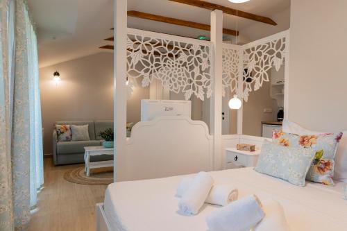 a white bedroom with a bed and a living room at Villa La Varik 1 in Litochoro