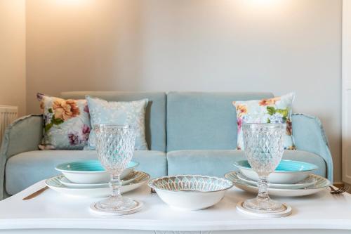 a table with two glasses and plates on a couch at Villa La Varik 1 in Litochoro