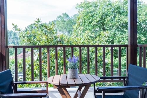 a table on a porch with two chairs and a table with flowers at Villa La Varik 1 in Litochoro