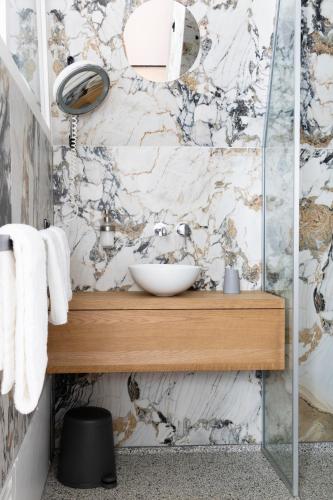 a bathroom with a sink and a marble wall at De 6 Linden Boutique Hotel in Sluis