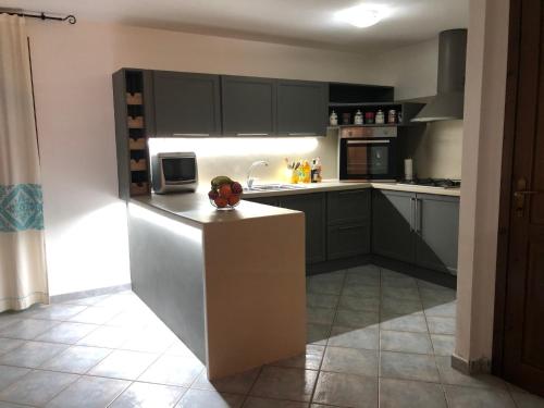 a kitchen with black cabinets and a refrigerator at VILLETTA SUL MARE, PANORAMICA in Villaputzu