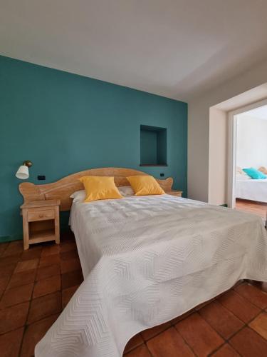 1 dormitorio con 1 cama grande y pared azul en Casa Fifina Rooms, en Sant'Egidio del Monte Albino
