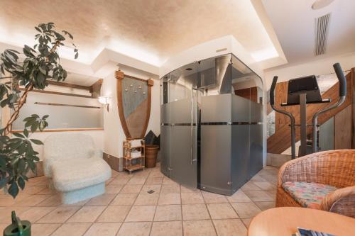 a living room with a refrigerator and a chair at Alpenhof in Lermoos