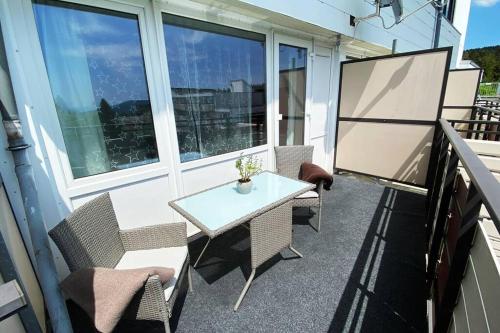 a patio with a table and chairs on a balcony at PENTHOUSE mitten im BAYERISCHEN WALD +NETFLIX +AUSSICHT = SUPER COZY in Sankt Englmar