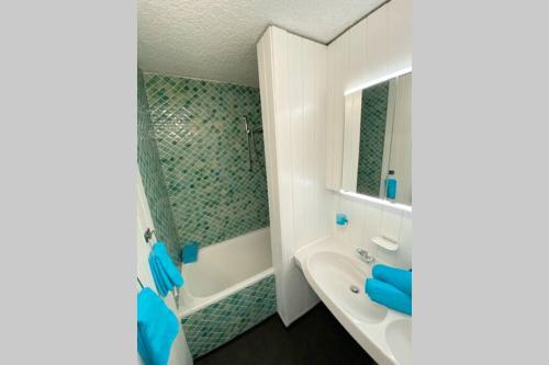 ein Badezimmer mit einem weißen Waschbecken und einer Dusche in der Unterkunft PENTHOUSE mitten im BAYERISCHEN WALD +NETFLIX +AUSSICHT = SUPER COZY in Sankt Englmar