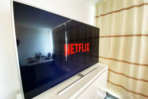a flat screen tv on a wall in a room at PENTHOUSE mitten im BAYERISCHEN WALD +NETFLIX +AUSSICHT = SUPER COZY in Sankt Englmar