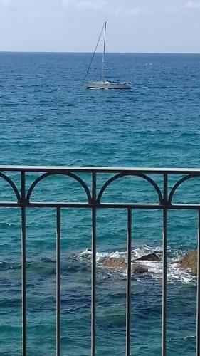 a sailboat in the ocean with a boat in the water at Marina Holiday Home in Pizzo