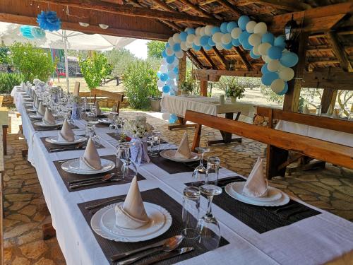 uma mesa longa com chapéus e pratos em Country House Peace em Drinovci