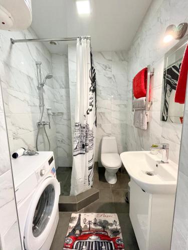 a bathroom with a washing machine and a sink at Apartment Studio PARIS 2 in Irpin