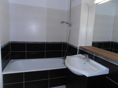 une salle de bain avec un lavabo et une baignoire dans l'établissement Adartza - Bien moderne avec grand balcon et parking, à Saint-Jean-de-Luz