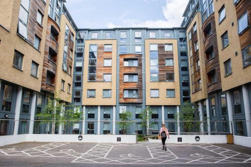 una mujer caminando en un patio frente a los edificios en Student Only Chapter Islington in London, en Londres