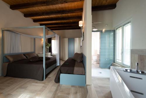 a bedroom with a bed and a bathroom with a tub at Agriturismo La Galizia in Cuggiono