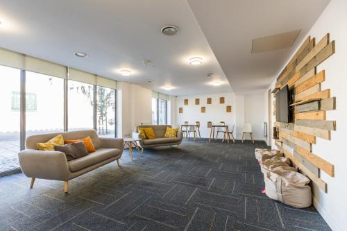 a lobby with couches and a wall of windows at For Students Only Stoneworks in Brighton in Brighton & Hove