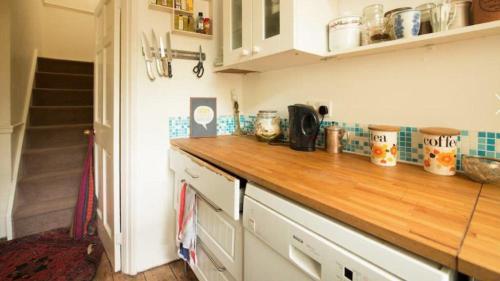 a kitchen counter with a wooden counter top at Lovely 3-Bed House in Cheltenham in Cheltenham