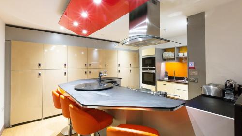 - une cuisine avec un évier et des chaises orange dans l'établissement Modern and Comfy Studios at Corporation Village in Coventry, à Coventry
