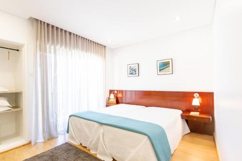 - une chambre avec un lit et une grande fenêtre dans l'établissement Apartamento Mar & Sol, à Póvoa de Varzim