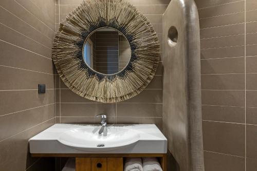 a bathroom with a sink and a mirror at Anastasia Hotel & Suites Mediterranean Comfort in Karistos