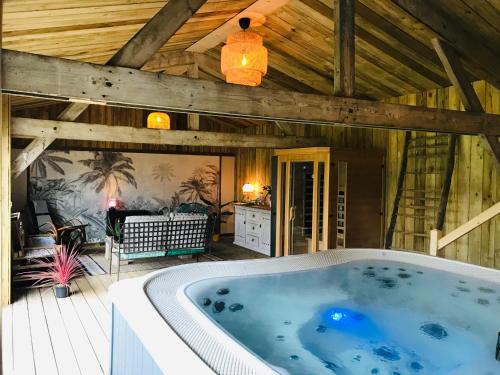 bañera de hidromasaje en una habitación con techo de madera en Domaine des Z'Ailés en Saint-Florent-des-Bois