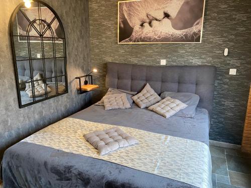 a bedroom with a bed with pillows on it at HOTEL NATURE LE LOFT in Pierrelatte