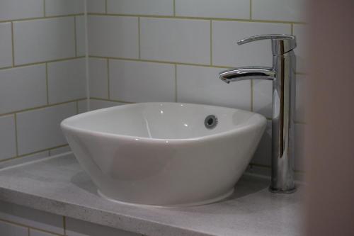 a white sink with a faucet in a bathroom at Hellidon Lakes Hotel in Daventry