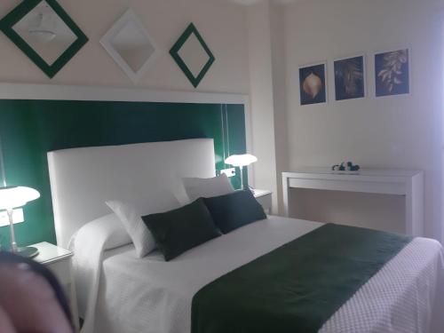a bedroom with a bed with green and white at La Gomera in Gran Tarajal
