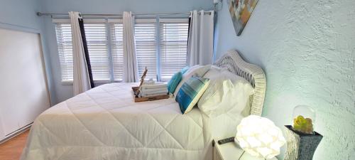 a bedroom with a white bed and a window at Lake Worth Beach Paradise Cove Cottage 2-1Bedroom in Lake Worth