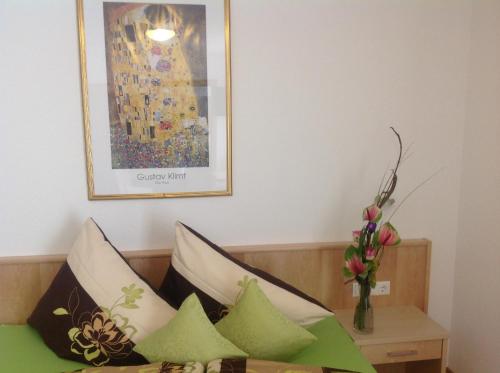 a bed with pillows and a picture on the wall at fabienne - Silvretta Premium Card Betrieb in Galtür
