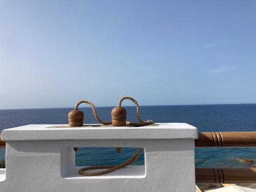 a table with a rope on it next to the ocean at Toxotis Villas in Armenistis