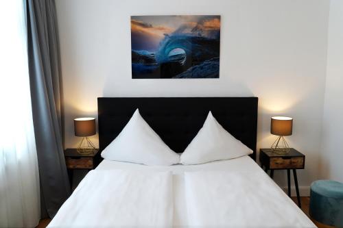 Hotel im Kupferkessel في كولونيا: غرفة نوم بسرير ابيض ومصباحين