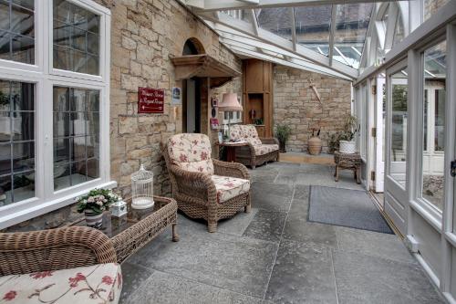 an outdoor patio with chairs and a glassconservatory at The Grange at Oborne in Sherborne