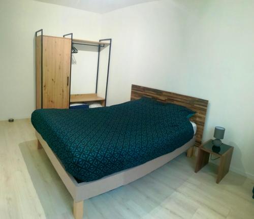 una camera da letto con un letto con un piumone verde di Maison à la campagne,à Saint-amand, Pas-de-Calais a Saint-Amand