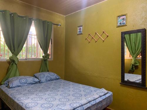 een slaapkamer met een bed en een spiegel bij !QUE TUANIS! in Guanacaste