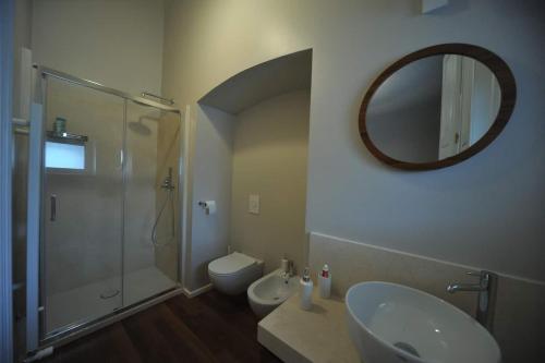 ein Badezimmer mit einem Waschbecken, einem WC und einem Spiegel in der Unterkunft Palazzo Ietri Corso Vittorio Emanuele ROOMS in Bari