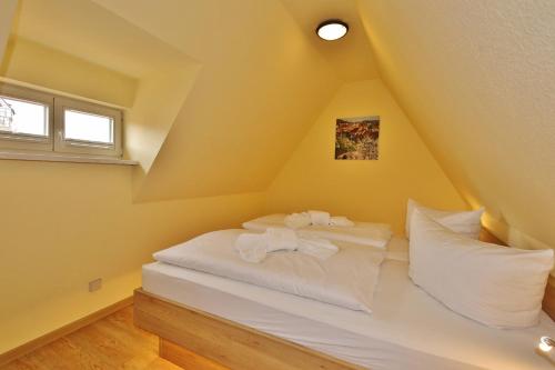 a bedroom with yellow walls and a bed with white pillows at Maria Aurora in Quedlinburg