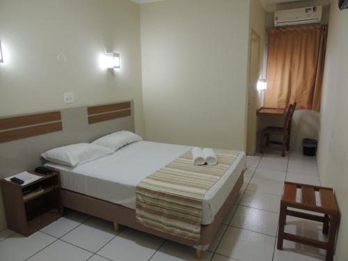ein Schlafzimmer mit einem Bett mit zwei Handtüchern darauf in der Unterkunft Perola Verde Hotel in Birigui