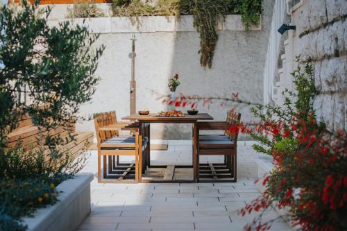 een houten tafel en stoelen op een terras bij Villa Paulina in Dubrovnik