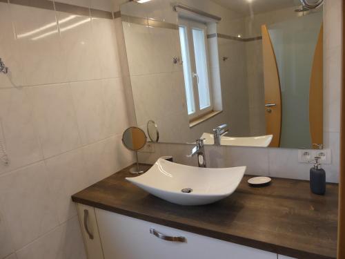 La salle de bains est pourvue d'un lavabo et d'un miroir. dans l'établissement Gîte du Paquis, à Florenville
