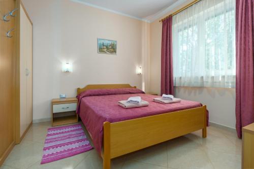 ein Schlafzimmer mit einem Bett mit zwei Handtüchern darauf in der Unterkunft Apartments Maria in Poreč