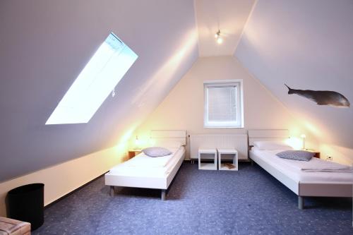 a attic room with two beds and a window at Parkoase 3, Maisonette Wohnung mit Balkon in Wangerooge