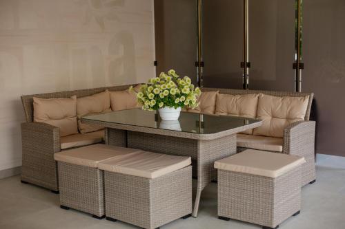 a table and chairs with a couch and a table and flowers at Villa San-Marina in Zatoka