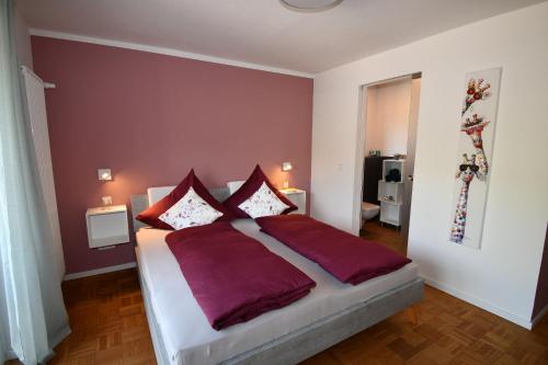 a bedroom with a large bed with purple walls at Schorn³ Appartements in Zell an der Mosel